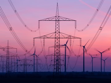 Stromnetz mit Windkraftanlagen im Hintergrund Stromnetz mit Windkraftanlagen im Hintergrund