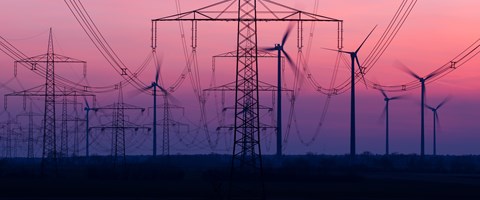 Stromnetz mit Windkraftanlagen im Hintergrund Stromnetz mit Windkraftanlagen im Hintergrund