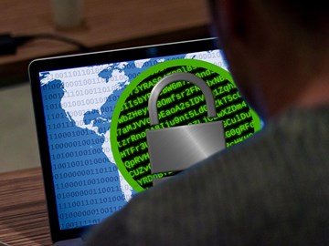 Cyberkriminalität Cyberkriminalität: Mann vor einem Laptop mit einem Schloss