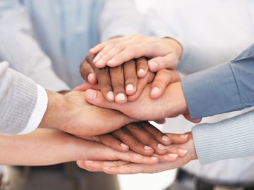 8 Hände liegen übereinander 8 Hände liegen übereinander