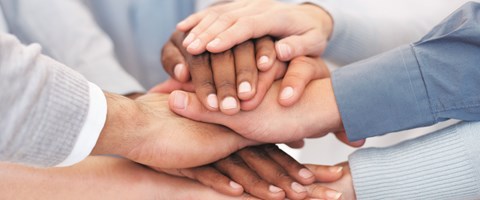 8 Hände liegen übereinander 8 Hände liegen übereinander