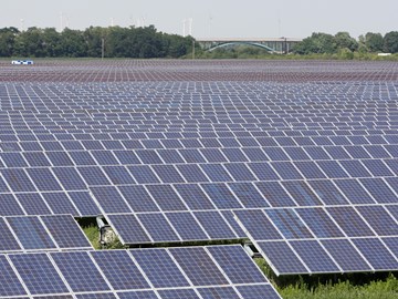 Große Photovoltaik-Anlage auf Feld vor Brücke Große Photovoltaik-Anlage auf Feld vor Brücke