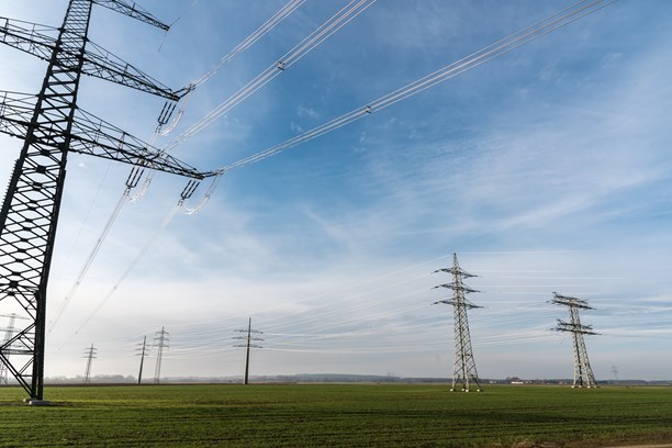 Strommasten auf einem grünen Feld Strommasten auf einem grünen Feld