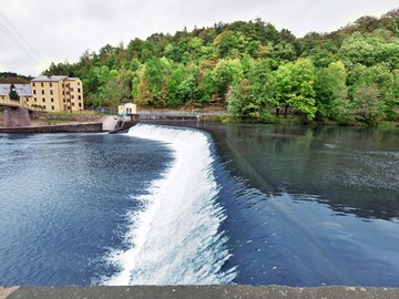 Wasserkraftwerk außen Überlauf mit schäumendem Wasser Wasserkraftwerk außen Überlauf mit schäumendem Wasser