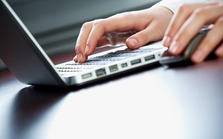 Hände an Maus und Laptop-Tastatur Hände an Maus und Laptop-Tastatur