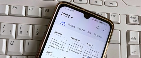 Smartphone auf Tastatur mit Kalender 2022 Smartphone auf Tastatur mit Kalender 2022