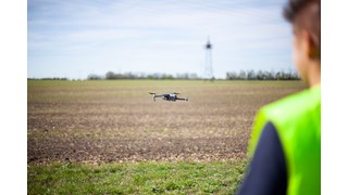 Kollege von MITNETZ STROM mit einer Drohne, die über ein Feld fliegt Kollege von MITNETZ STROM mit einer Drohne, die über ein Feld fliegt