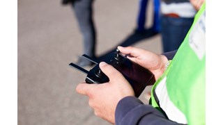 Kollege von MITNETZ STROM bei der Leitungsinspektion mit einer Drohnensteuerung in den Händen Kollege von MITNETZ STROM bei der Leitungsinspektion mit einer Drohnensteuerung in den Händen