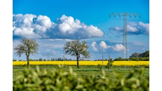 Strommasten auf einem Rapsfeld bei Kabelsketal unter blauem Himmel Strommasten auf einem Rapsfeld bei Kabelsketal unter blauem Himmel