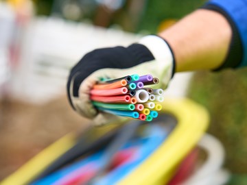 ein Mitarbeiter der envia TEL auf einer Baustelle mit einem Bündel Glasfaserkabel in der Hand ein Mitarbeiter der envia TEL auf einer Baustelle mit einem Bündel Glasfaserkabel in der Hand