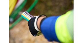 ein Mitarbeiter der envia TEL auf einer Baustelle mit einem Glasfaserkabel in der Hand ein Mitarbeiter der envia TEL auf einer Baustelle mit einem Glasfaserkabel in der Hand