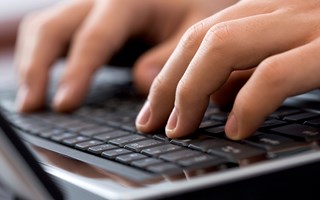 Detailaufnahme Hände an Notebook-Tastatur Detailaufnahme Hände an Notebook-Tastatur