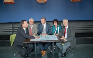 Kommunale Verteter begutachten sitzend eine Landkarte Kommunale Verteter begutachten sitzend eine Landkarte