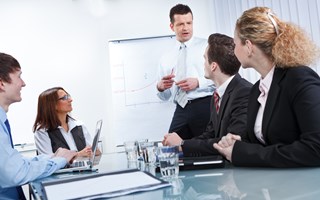 Austausch im Meeting vor Flip-Chart Austausch im Meeting vor Flip-Chart