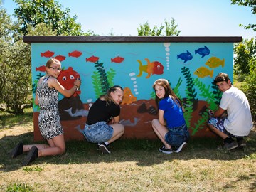 Graffiti-Präventionstag, 4 Jugendliche besprühen ein Verteilerhäuschen mit Aquarium-Motiv Graffiti-Präventionstag, 4 Jugendliche besprühen ein Verteilerhäuschen mit Aquarium-Motiv