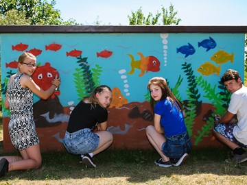 Graffiti-Präventionstag, 4 Jugendliche besprühen ein Verteilerhäuschen mit Aquarium-Motiv Graffiti-Präventionstag, 4 Jugendliche besprühen ein Verteilerhäuschen mit Aquarium-Motiv