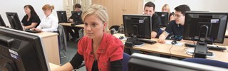 Zahlreiche Auszubildende sitzen vor Computern in einem Schulungsraum Zahlreiche Auszubildende sitzen vor Computern in einem Schulungsraum