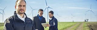 Männer vor Windkraftanlagen Männer vor Windkraftanlagen