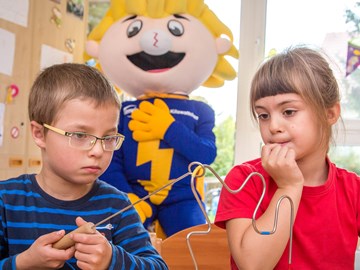 Kinder beobachten ein Energie-Experiment Kinder beobachten ein Energie-Experiment