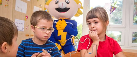 Kinder beobachten ein Energie-Experiment Kinder beobachten ein Energie-Experiment