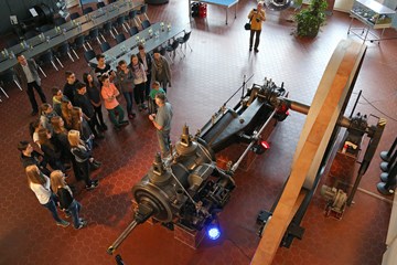 Schülergruppe besichtigt eine große historische Dampfmaschine Schülergruppe besichtigt eine große historische Dampfmaschine