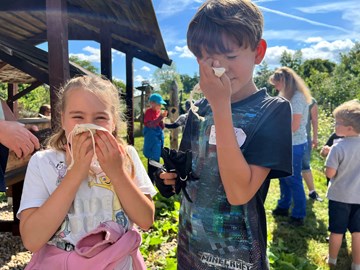Ökogarten Quedlinburg Ökogarten Quedlinburg, zwei Kinder riechen an selbstgemachten Duftsäckchen. Im Hintergrund sind weitere Kinder und eine erwachsene Frau im Ökogarten zu sehen.