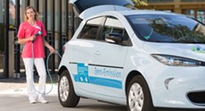 Krankenschwester betankt ein Elektroauto Krankenschwester betankt ein Elektroauto
