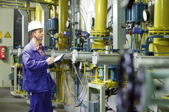 Mann mit Notizblock an Energieerzeugungsanlage Mann mit Notizblock an Energieerzeugungsanlage