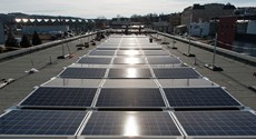 Größere Photovoltaik-Anlage auf einem Flachdach schimmert in der Sonne Größere Photovoltaik-Anlage auf einem Flachdach schimmert in der Sonne