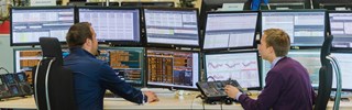 Energiehändler sitzen vor Monitoren Energiehändler sitzen vor Monitoren